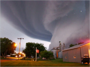 Large tornado moving towards a house in a rural area