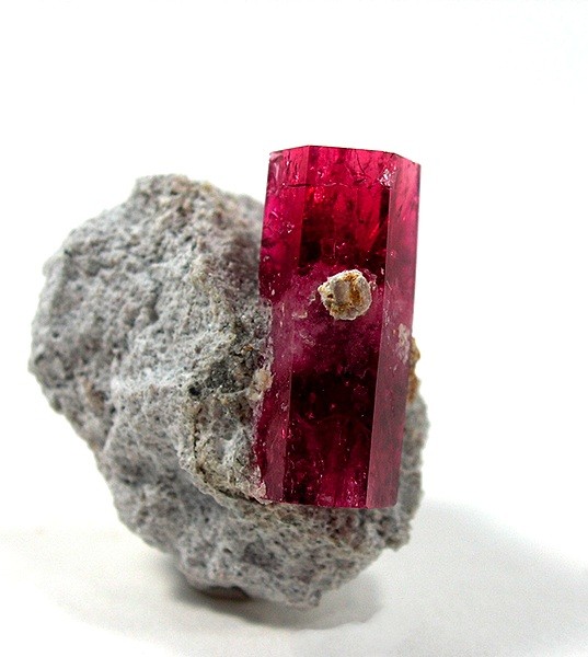 Red Beryl in a crystal perched on white rhyolite matrix
