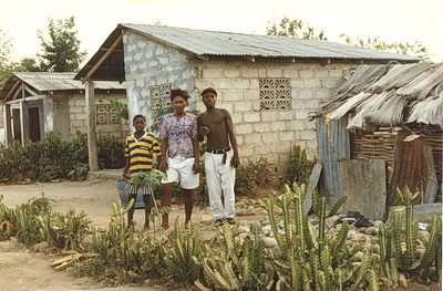 Haitian family outside of their cinder block house