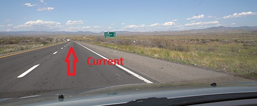 Car on empty road with arrow that says "Current"