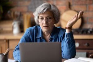 Woman gestering in awe looking at computer laptop