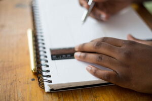 Man using ruler on notebook